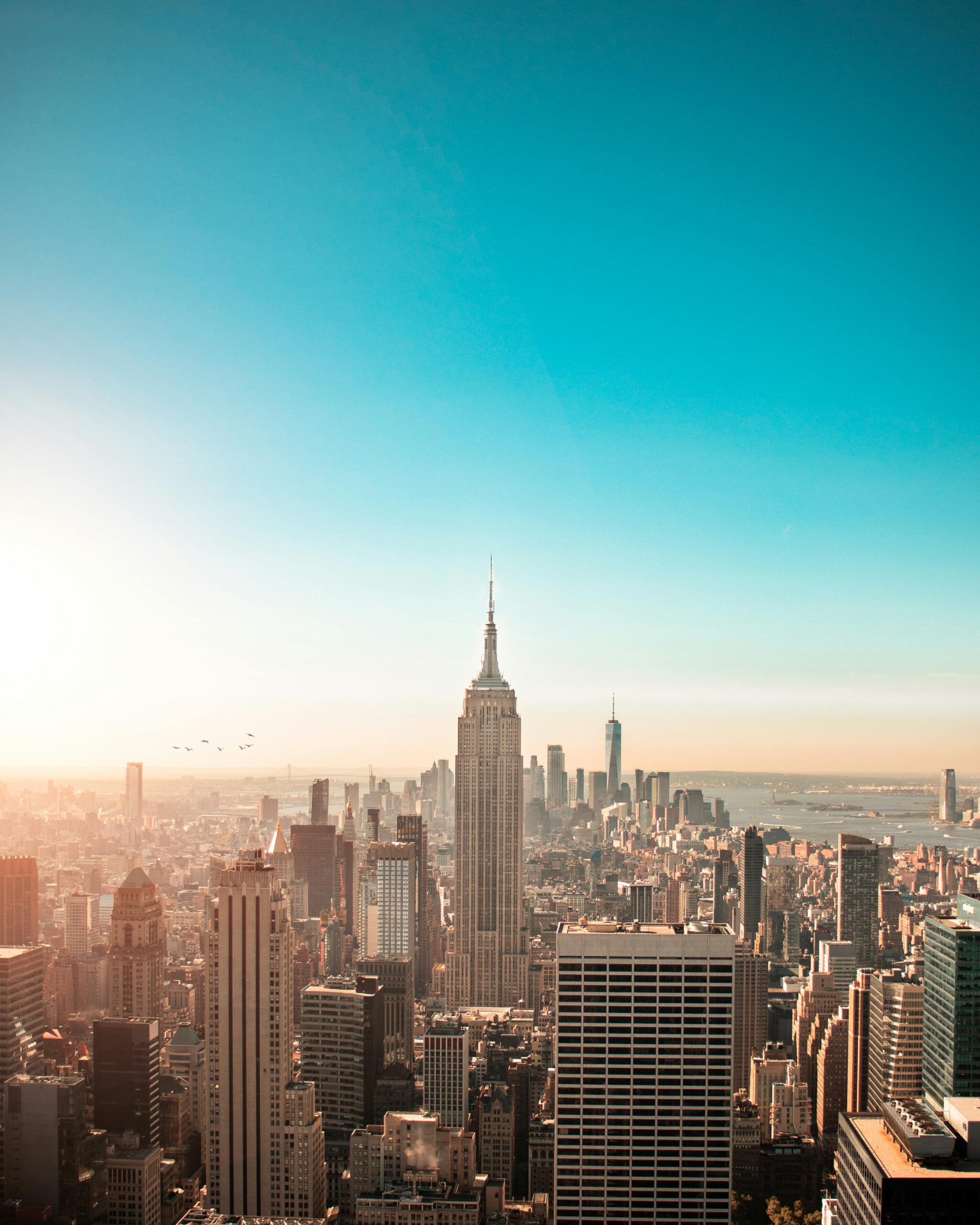 Breathtaking view of New York City's skyline featuring the iconic Empire State Building at sunrise.