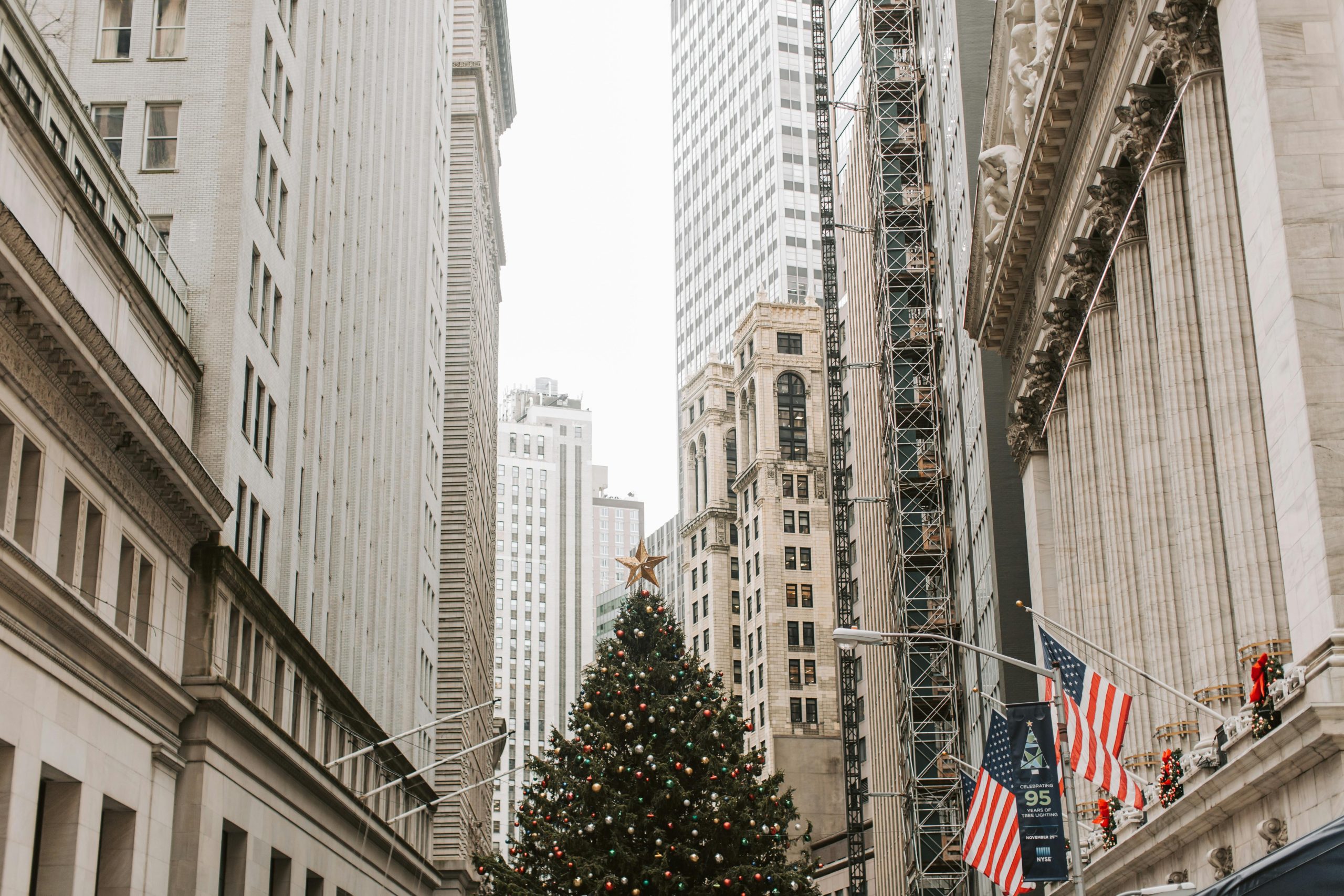 Festive Christmas tree surrounded by skyscrapers in Wall Street, New York City.