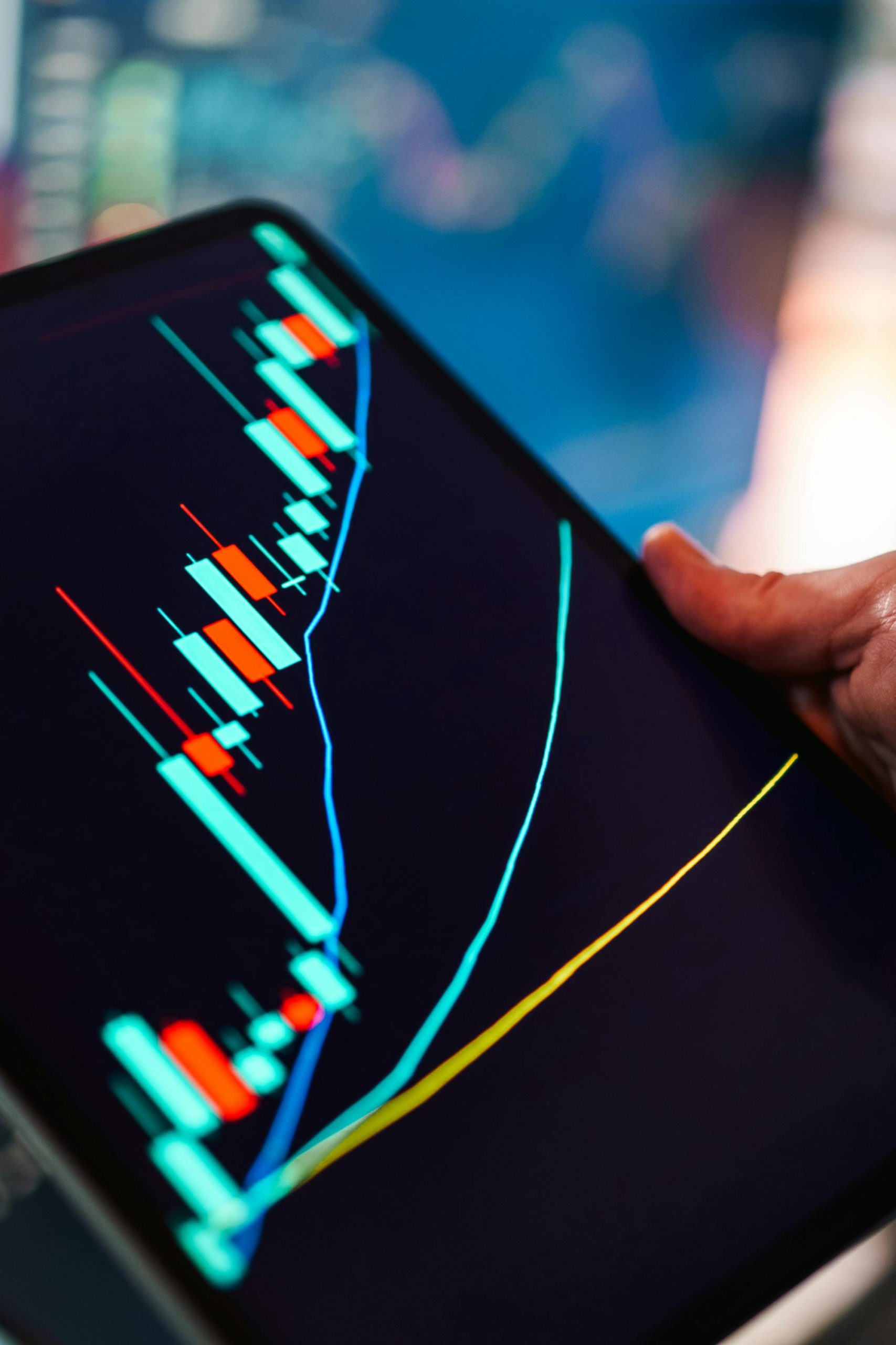 A close-up of a tablet displaying a colorful candlestick chart, ideal for finance and technology themes.